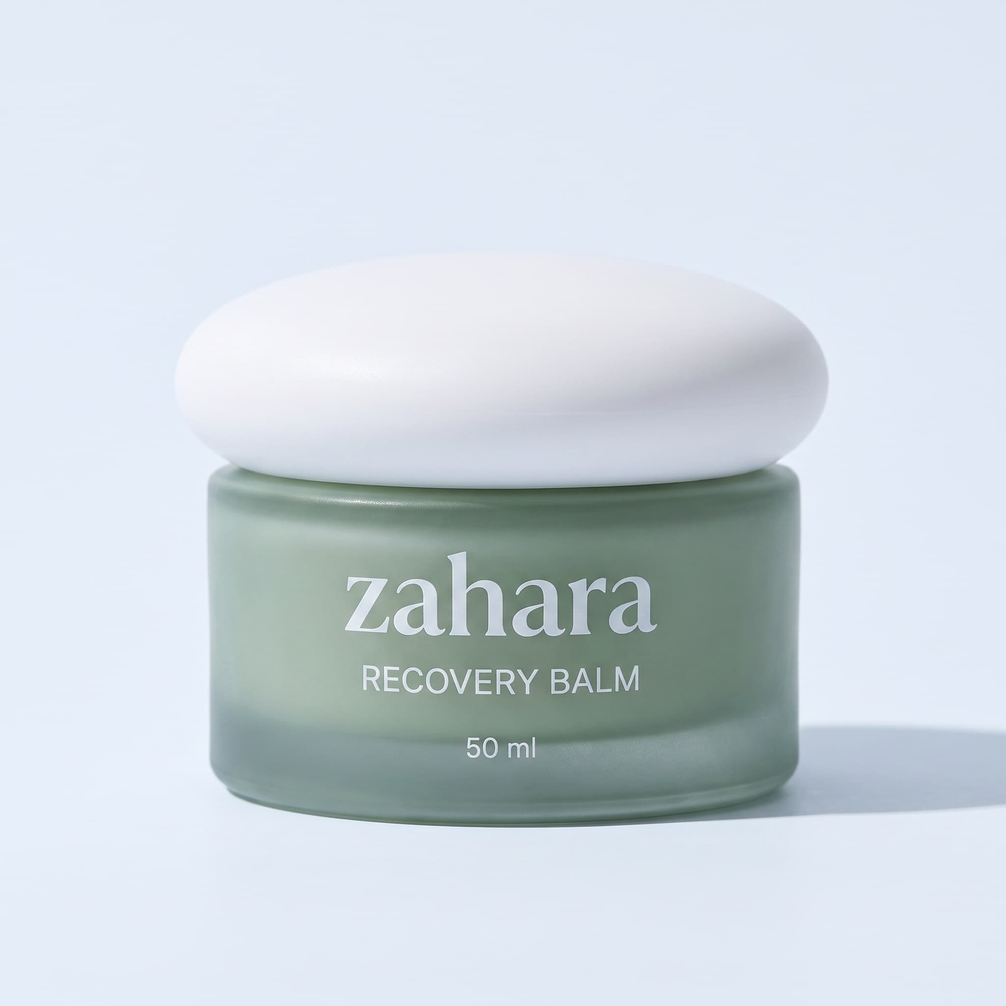 Zahara Recovery Balm packshot: sage-to-moss gradient jar with a white pebble lid.
